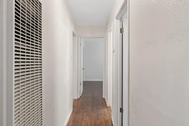 a view of a hallway with wooden floor