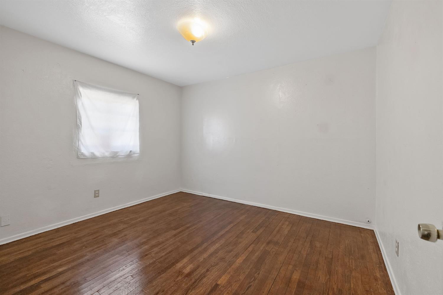 400 Scott Street Hanford, CA 93230 - Photo 26 of 35 an empty room with wooden floor and windows