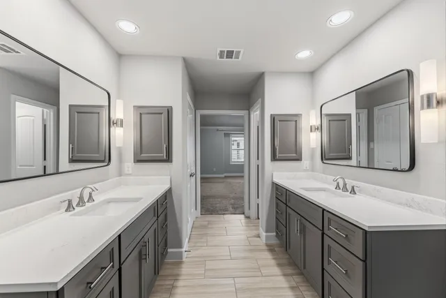 a bathroom with a sink double vanity granite tub shower and a mirror