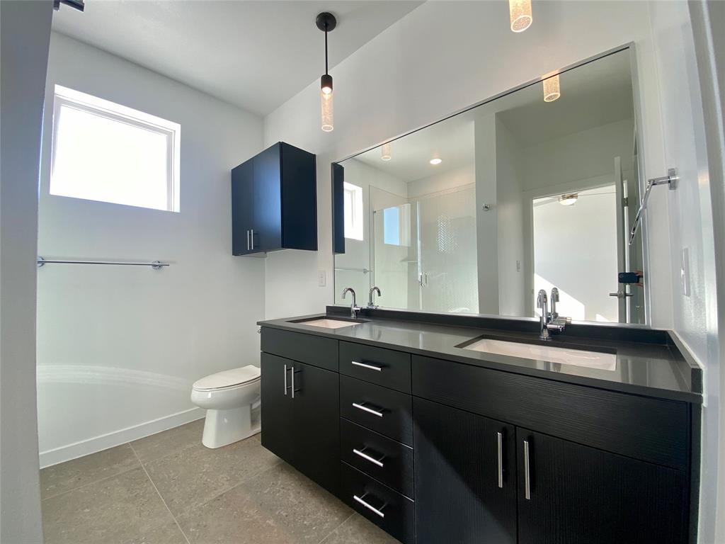 4801 Springdale Road, Unit 2408 Austin, TX 78723 - Photo 7 of 22 a bathroom with a granite countertop sink a toilet and mirror
