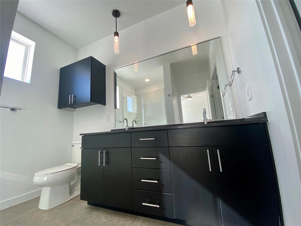 4801 Springdale Road, Unit 2408 Austin, TX 78723 - Photo 8 of 22 a bathroom with a sink a toilet and mirror