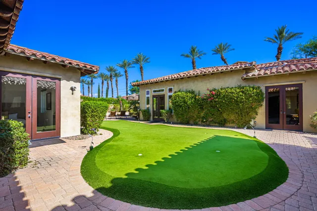 a view of a house with backyard and sitting area