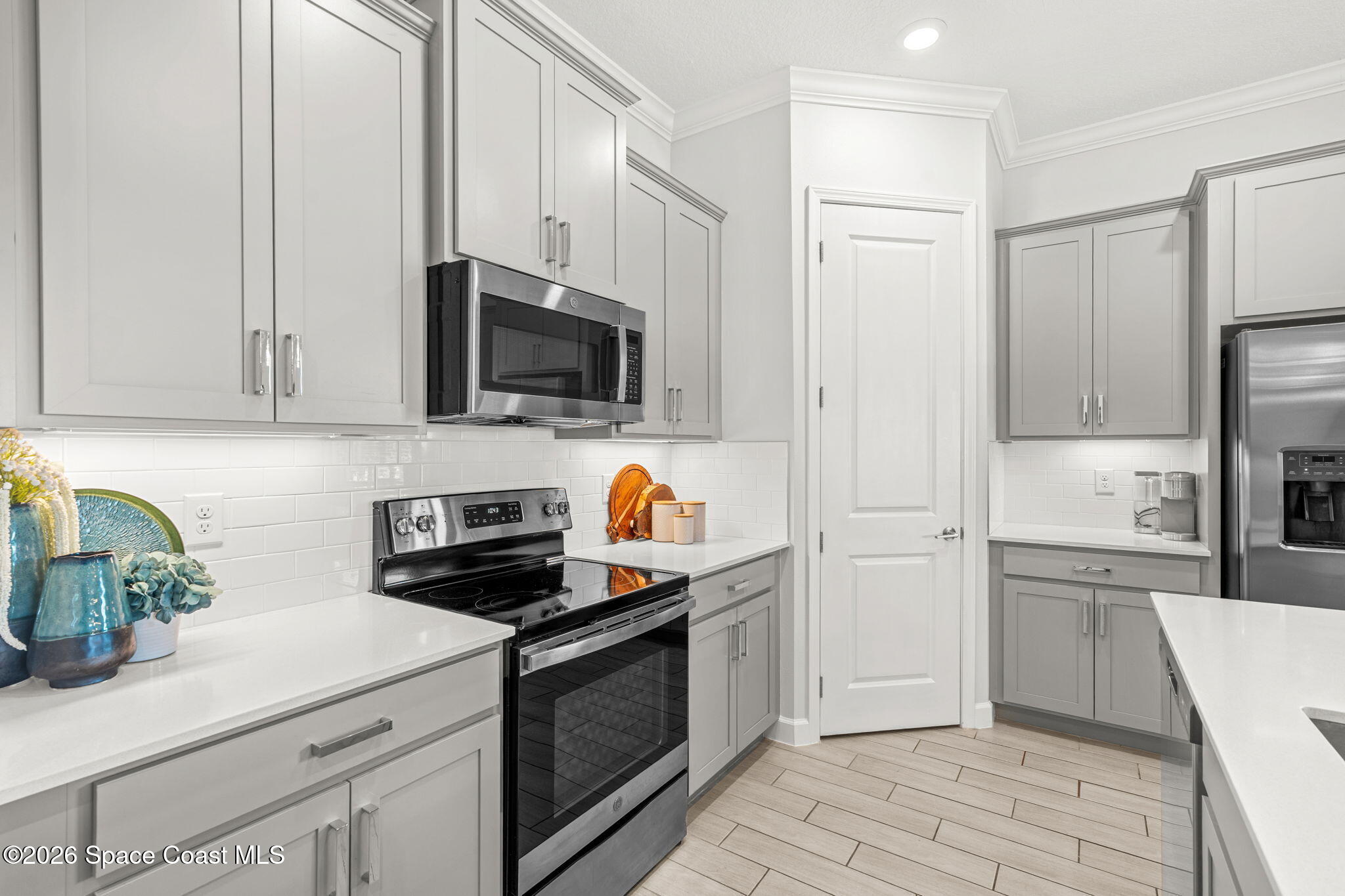 8904 Alister Drive Melbourne, FL 32940 - Photo 17 of 91 a kitchen with stainless steel appliances granite countertop a refrigerator a stove a sink and white cabinets