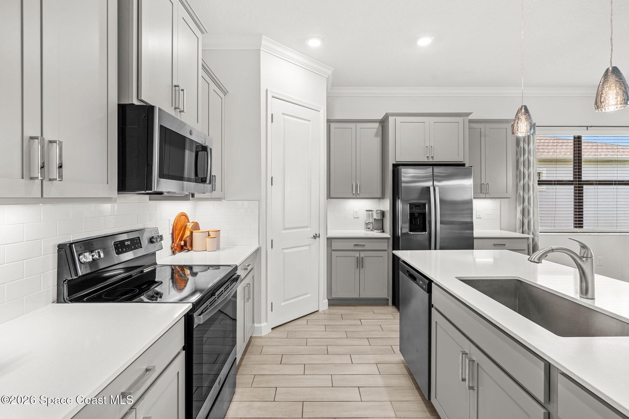 8904 Alister Drive Melbourne, FL 32940 - Photo 6 of 91 a kitchen that has a sink cabinets counter space and stainless steel appliances