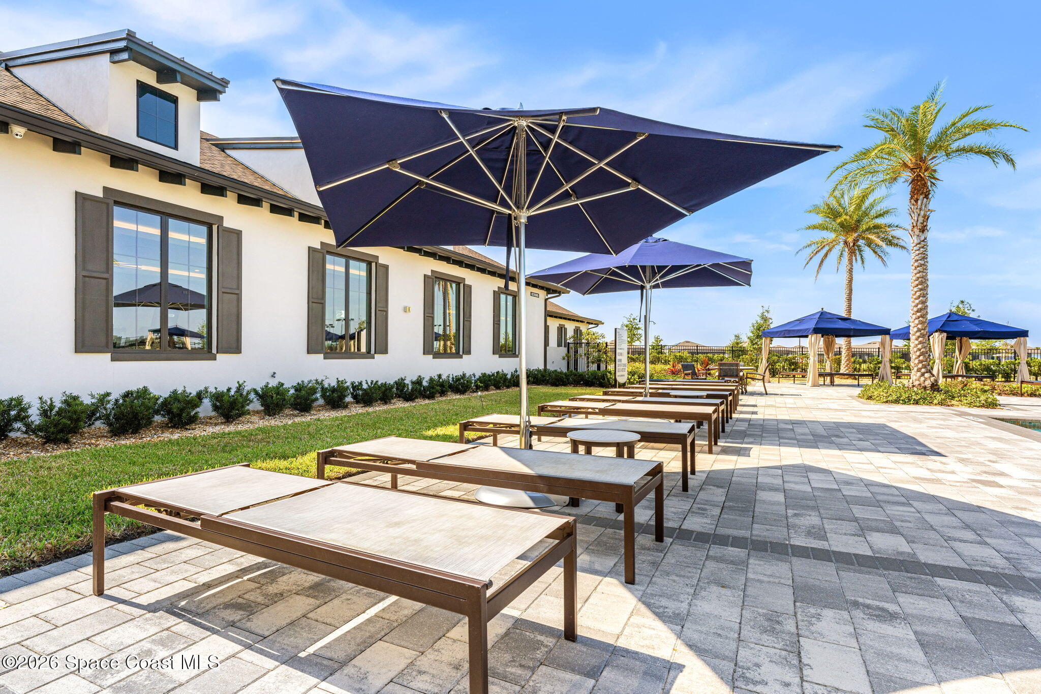 8904 Alister Drive Melbourne, FL 32940 - Photo 87 of 91 a patio with a table and chairs under an umbrella