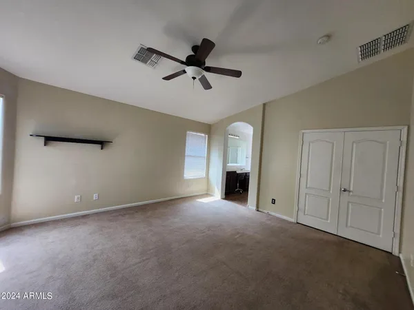 a view of an empty room with window and cabinet