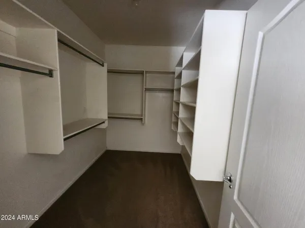 a view of walk in closet with empty racks