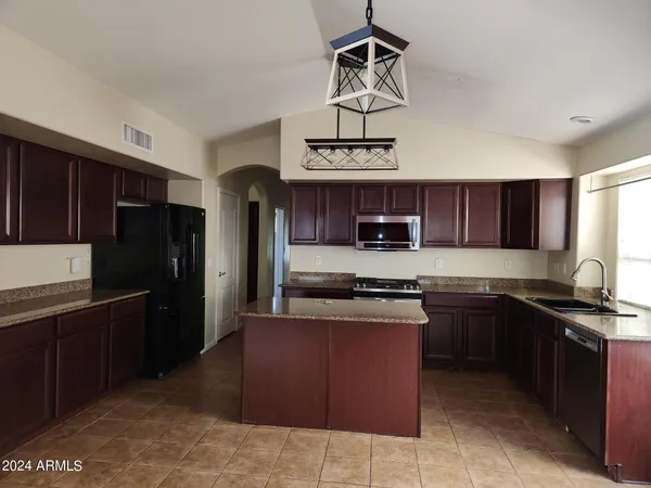 a kitchen with stainless steel appliances granite countertop a sink and stove top oven