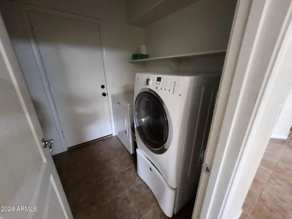 a utility room with washing machine and a view of bedroom