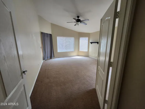 a view of a room with a windows and ceiling fan