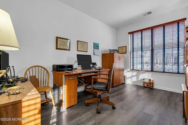 a view of a workspace with furniture and a window