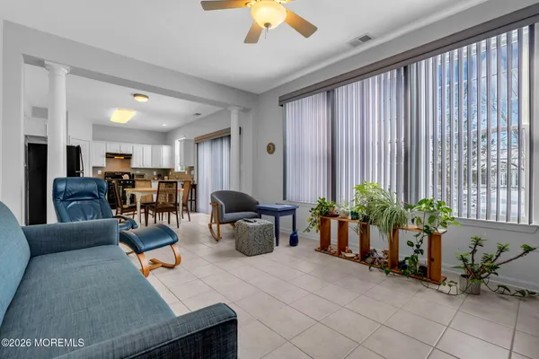 a living room with furniture and potted plants