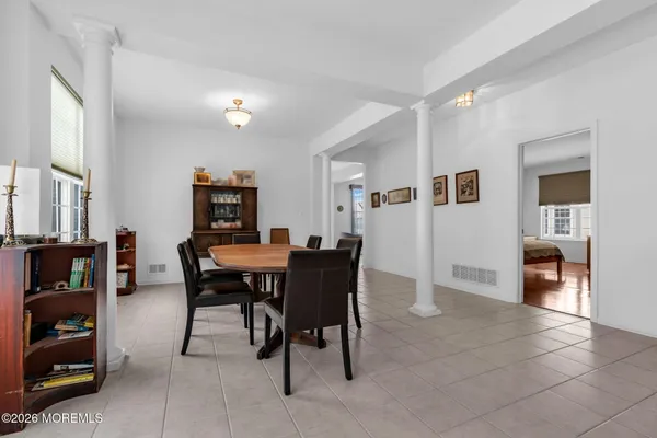 a kitchen with stainless steel appliances granite countertop a dining table chairs refrigerator and sink