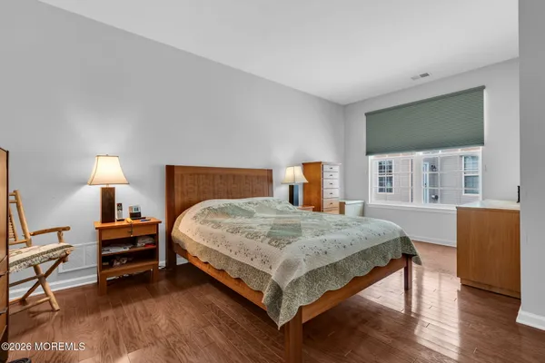 a bedroom with a bed wooden floor and window