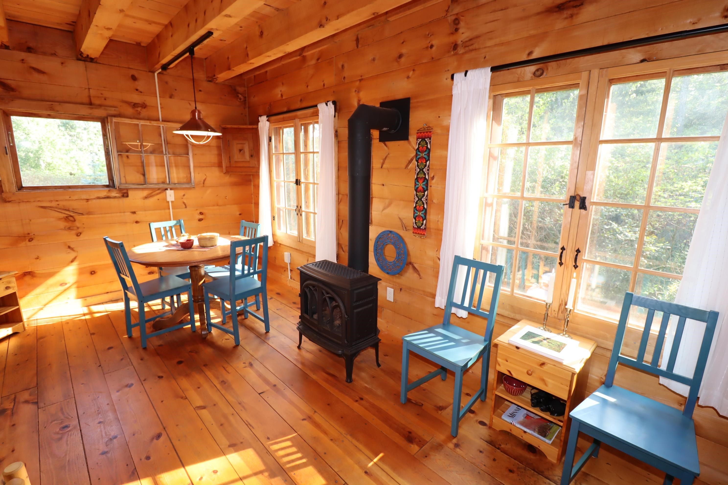 89595 Bark Point Road Herbster, WI 54844 - Photo 14 of 43 Dining area with beam ceiling, plenty of natural light, hardwood floors, and a gas stove
