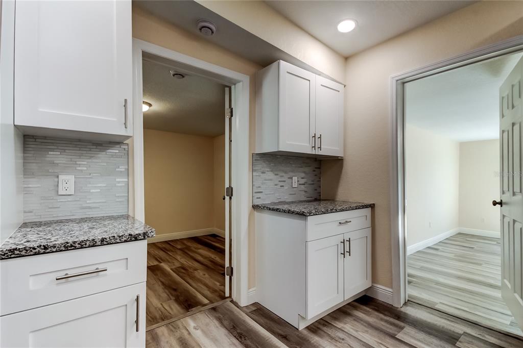 1353 Mary L Road Clearwater, FL 33755 - Photo 11 of 44 a kitchen with granite countertop white cabinets and white appliances