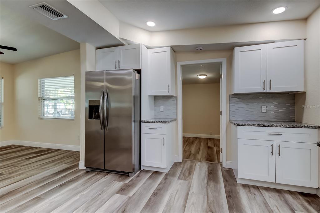 1353 Mary L Road Clearwater, FL 33755 - Photo 15 of 44 a kitchen with granite countertop a refrigerator and a stove top oven