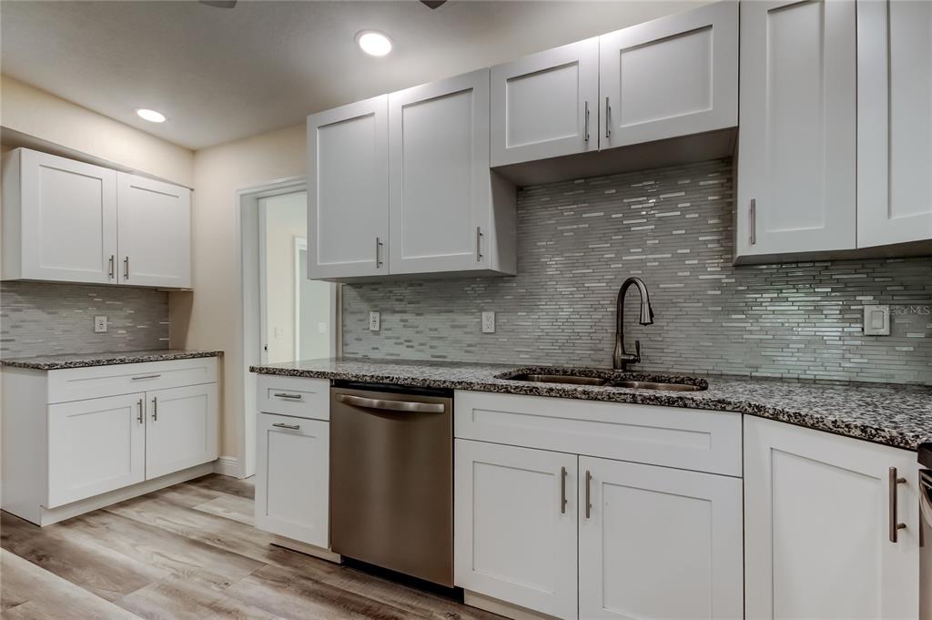 1353 Mary L Road Clearwater, FL 33755 - Photo 16 of 44 a kitchen with granite countertop white cabinets and white appliances