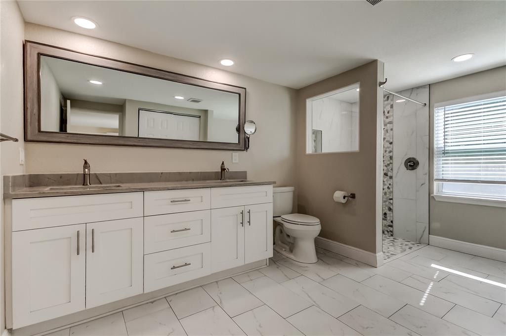 1353 Mary L Road Clearwater, FL 33755 - Photo 19 of 44 a bathroom with a granite countertop toilet sink and mirror