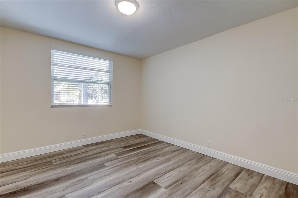 1353 Mary L Road Clearwater, FL 33755 - Photo 26 of 44 wooden floor in an empty room with a window