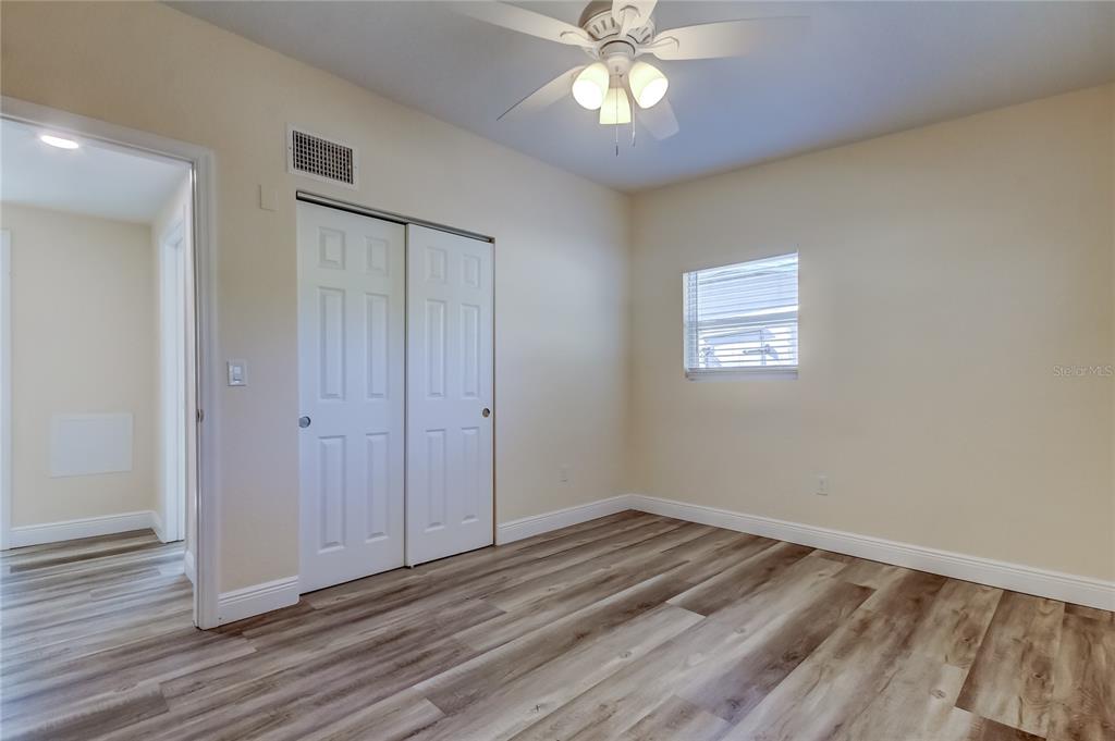 1353 Mary L Road Clearwater, FL 33755 - Photo 30 of 44 a view of a room with wooden floor and a ceiling fan