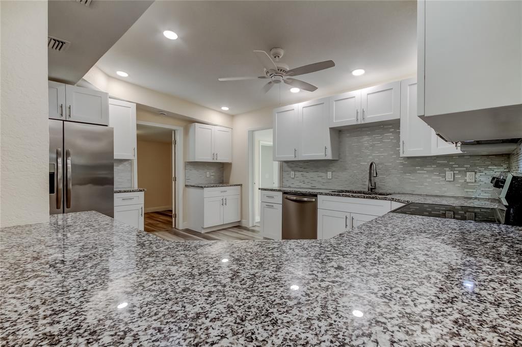 1353 Mary L Road Clearwater, FL 33755 - Photo 8 of 44 a large kitchen with stainless steel appliances kitchen island granite countertop a refrigerator and a sink