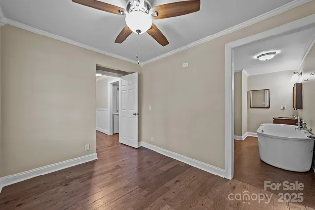 an empty room with wooden floor and ceiling fan
