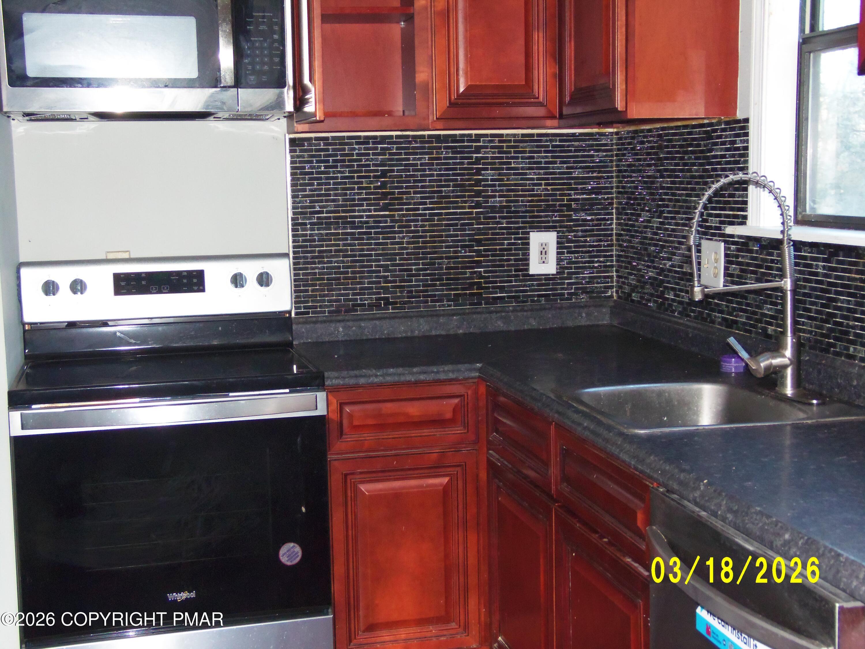 240 Powder Horn Road Henryville, PA 18332 - Photo 11 of 23 a kitchen with granite countertop a sink stove and cabinets