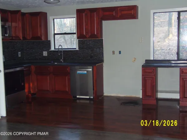 a kitchen with granite countertop wooden cabinets a sink and dishwasher