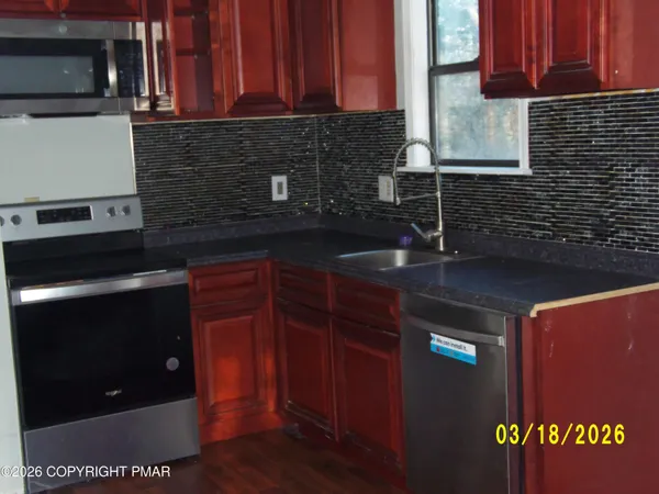 a kitchen with granite countertop wood cabinets and a stove top oven
