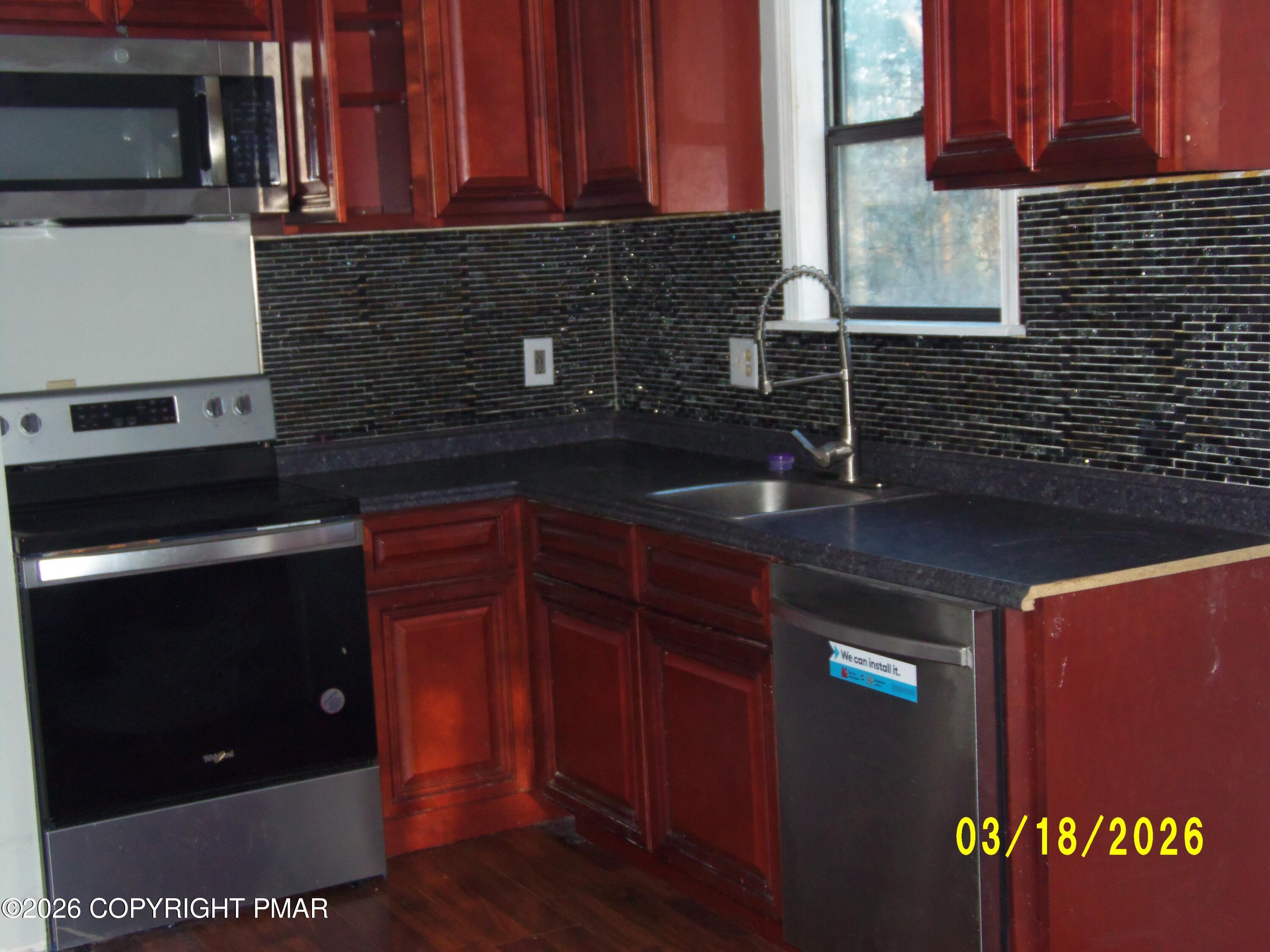 240 Powder Horn Road Henryville, PA 18332 - Photo 8 of 23 a kitchen with granite countertop wood cabinets and a stove top oven