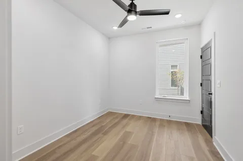 an empty room with a window and wooden floor