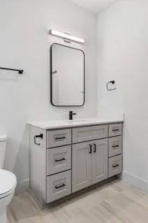 a bathroom with a toilet sink and mirror