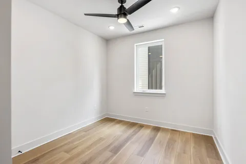 an empty room with a window and wooden floor