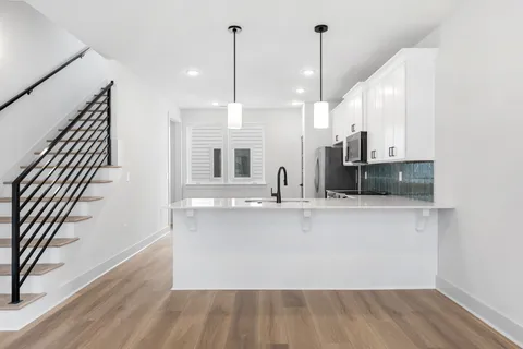 a view of a kitchen with kitchen island and wooden floor