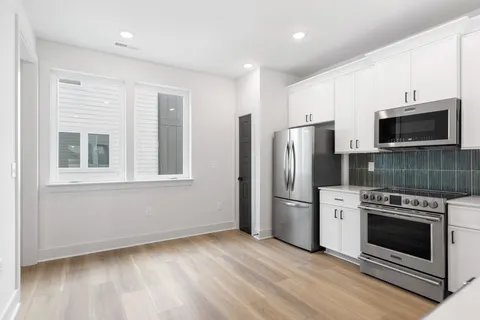a kitchen with stainless steel appliances a stove a refrigerator and a microwave