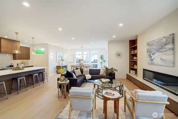a living room with furniture a rug and kitchen view