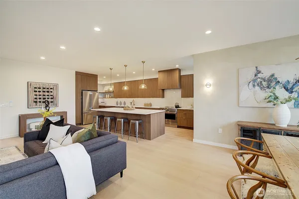 a kitchen with a stove a sink a kitchen island with chairs and wooden cabinets