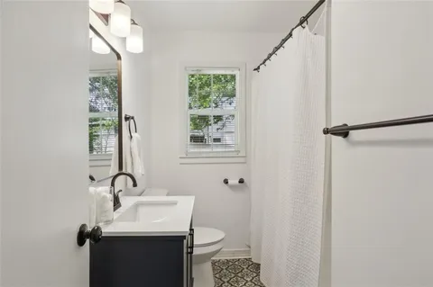 a bathroom with a sink toilet and a mirror