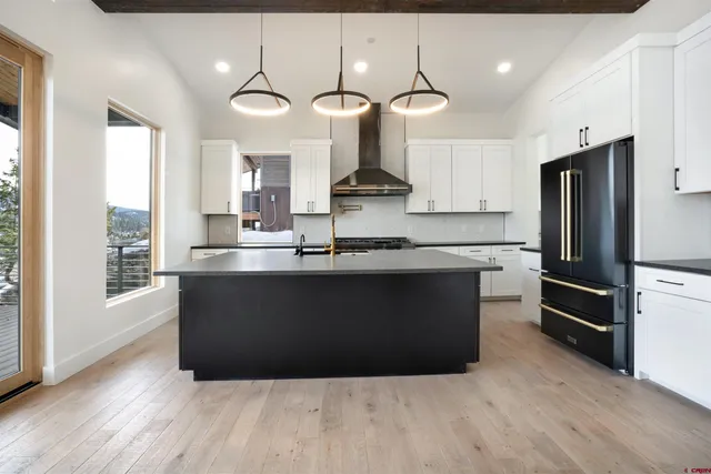 a kitchen with granite countertop a refrigerator and a stove top oven