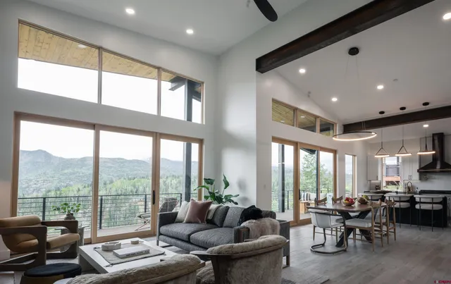 a living room with furniture and floor to ceiling windows