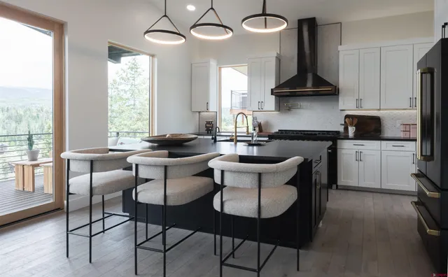 a kitchen with a dining table chairs sink and cabinets