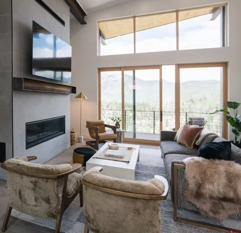 a living room with furniture a flat screen tv and a fireplace