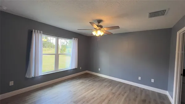 an empty room with a window and a fan