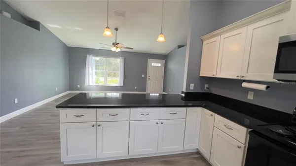 a kitchen with granite countertop a sink a stove and cabinets