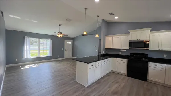 a kitchen with granite countertop a sink and cabinets