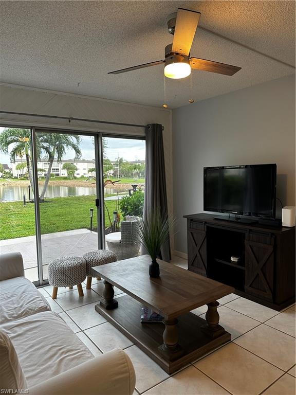 1000 Manatee Road, Unit A105 Naples, FL 34114 - Photo 3 of 22 a living room with couch a flat screen tv and a floor to ceiling window