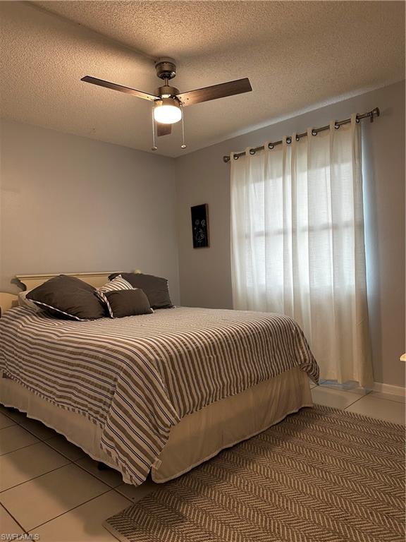 1000 Manatee Road, Unit A105 Naples, FL 34114 - Photo 6 of 22 a bedroom with a large bed and a chandelier