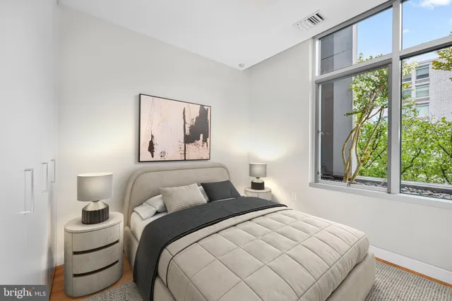 a bedroom with a bed and a large window