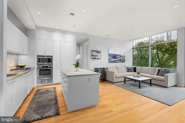 a living room with fireplace furniture and a large window